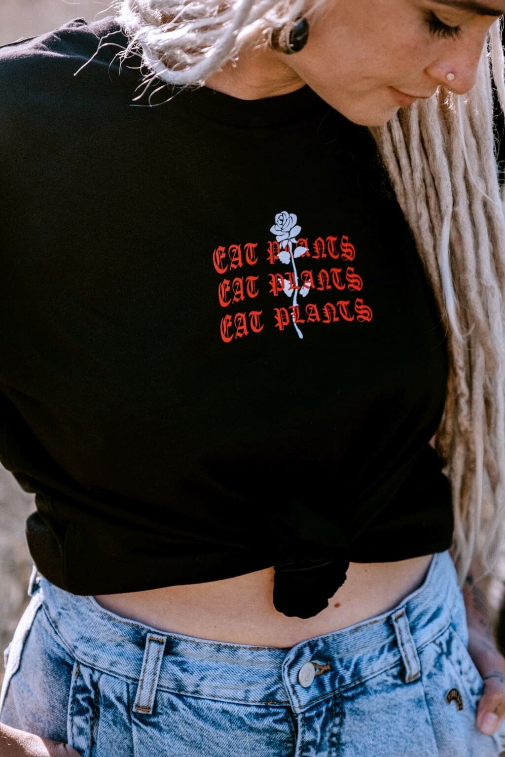 Detail eines schwarzen Shirts mit rotem Aufdruck Eat Rocks Eat Plants
