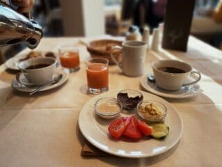 Veganer Fr&uuml;hst&uuml;ckstisch mit Kaffee, Saft und frischem Obst, perfekt f&uuml;r einen gesunden Start in den.