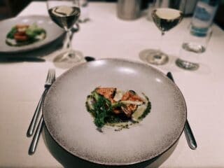 Veganer Gourmet-Teller mit frischem Gem&uuml;se, Tofu und Kr&auml;utern, serviert auf einem eleganten Teller.