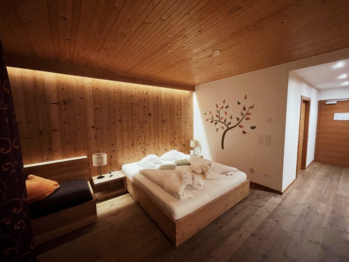 Veganer Schlafraum mit Holzdecke, Baumwandkunst und gem&uuml;tlicher Atmosph&auml;re.