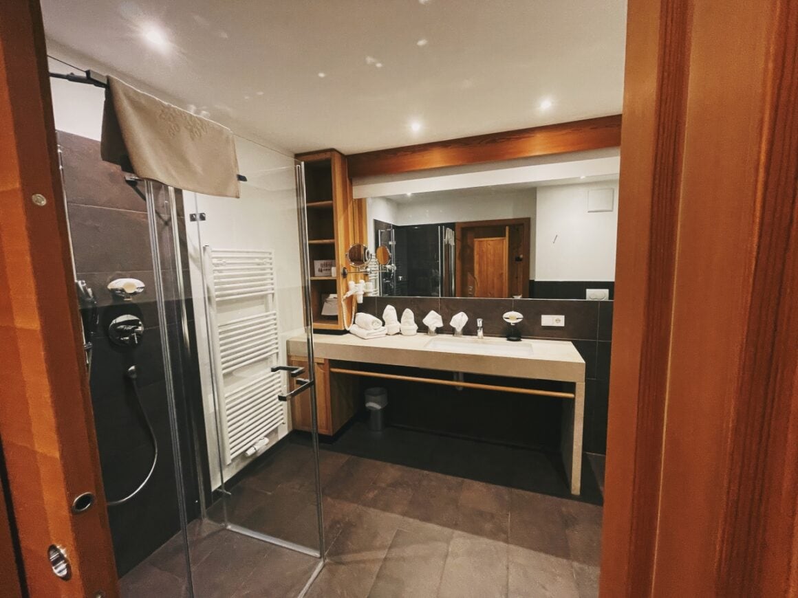 Veganes Badezimmer mit Holzdetails, gro&szlig;er Spiegel und moderne Ausstattung.