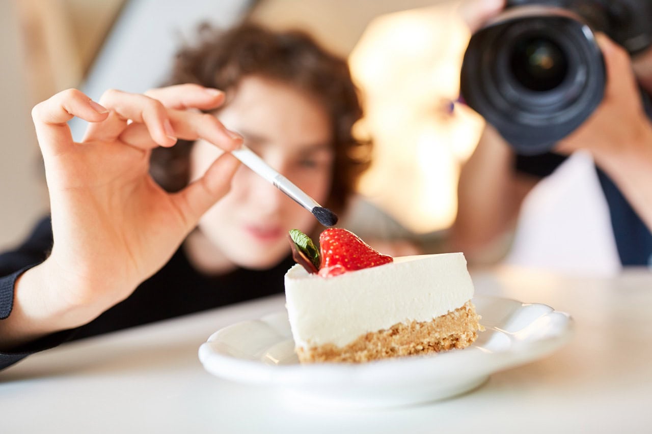 Content Creation, Food Fotografie und Vegan-Consulting Food Fotografen fotografieren Stück veganen Kuchen und präparieren diesen für das perfekte Foto