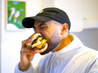 Chris Washington aka Vegane Wunder isst seinen veganen Burger