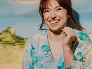 Bianca „Bibi“ Heinicke lächelnd vor Kunst