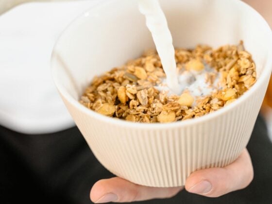 Pflanzliche Milch wird über Müsli gegossen - laktosefrei!
