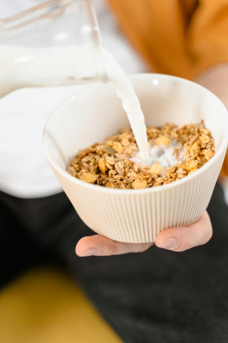 Pflanzliche Milch wird über Müsli gegossen - laktosefrei!