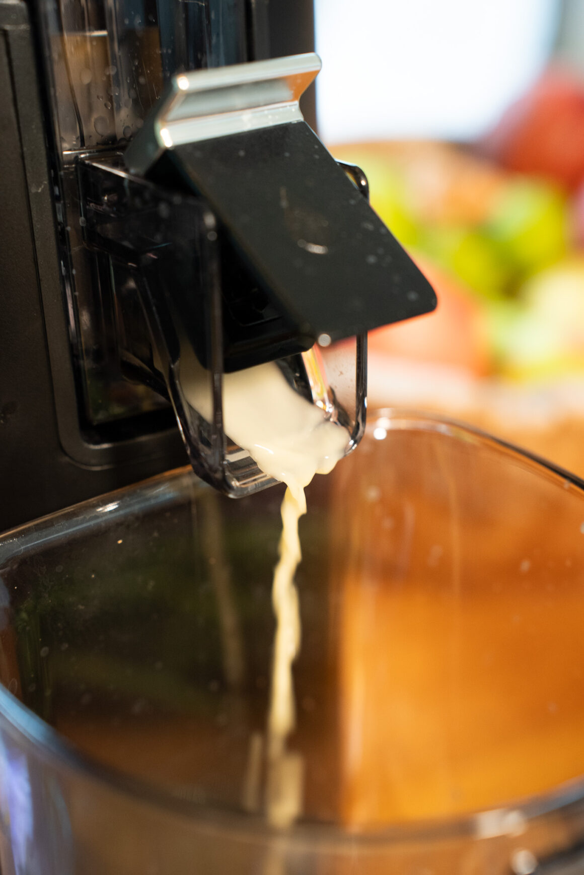 Frischer Saft fließt aus dem Auslauf des Hurom H70-ST in den Behälter – gleichmäßiger Stream, minimaler Schaum.