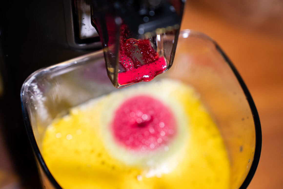 ntensiver Rote-Bete-Saft fließt aus dem Hurom H70-ST in gelben Saft – präziser Auslauf, leiser Cold-Press-Moment.
