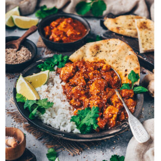 Cremiges veganes Butter Chicken mit Tofu, serviert mit Reis, Naan und frischen Kräutern