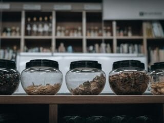 Gläser mit getrockneten Kräutern und Rindenstücken in einer asiatischen Apotheke