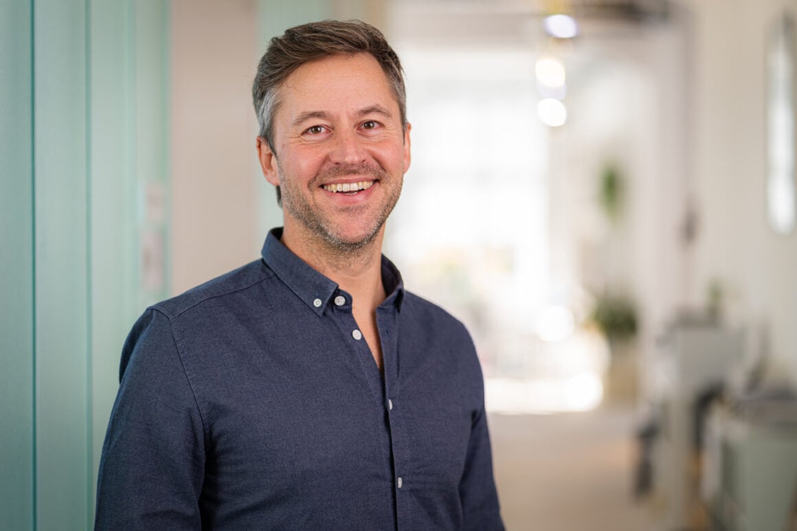 Florian Henle, Gründer und Geschäftsführer von Polarstern Energie, im Portrait mit dunkelblauem Hemd im Büro