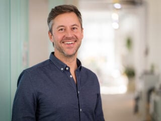 Florian Henle, Gründer und Geschäftsführer von Polarstern Energie, im Portrait mit dunkelblauem Hemd im Büro