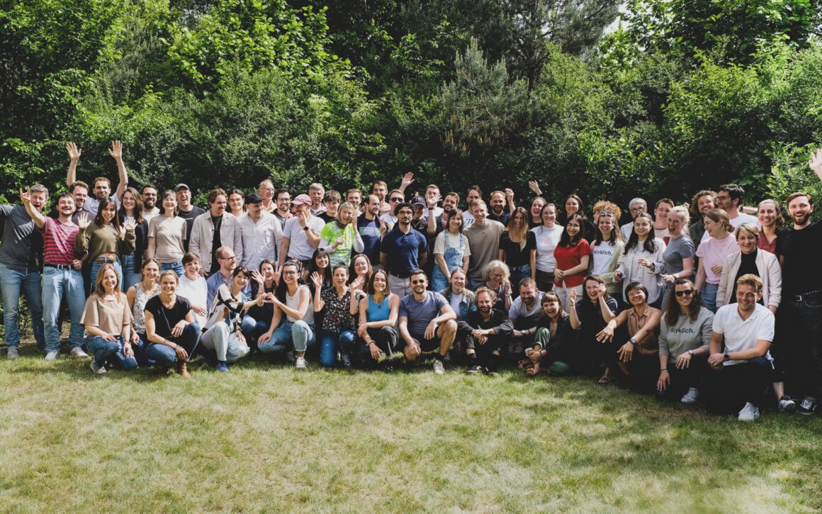 Das gesamte Polarstern-Team posiert für ein Gruppenfoto im Grünen, einige tragen T-Shirts mit der Aufschrift Wirklich