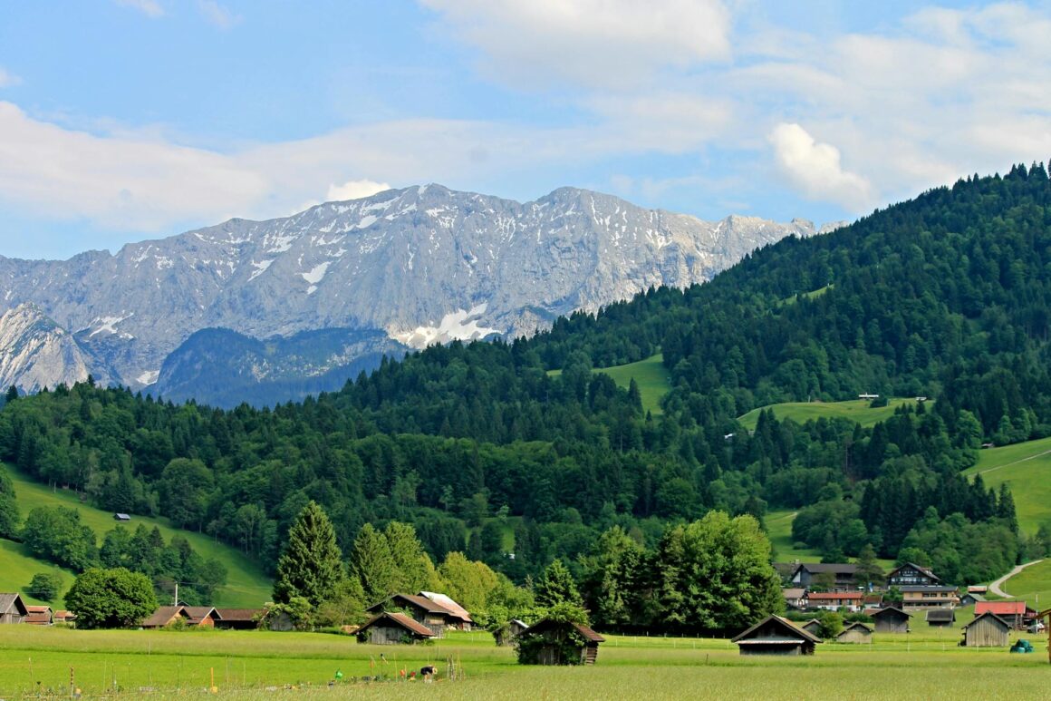 Schweizer Alpenlandschaft mit grünen Wiesen, traditionellen Bauernhöfen und schneebedeckten Bergen – Heimat des Familienunternehmens Züger in der Ostschweiz