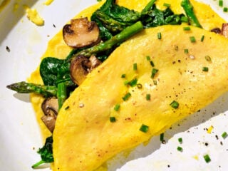 Veganes Omelett aus JUST Egg mit Spargel, Champignons und Spinat, bestreut mit Schnittlauch