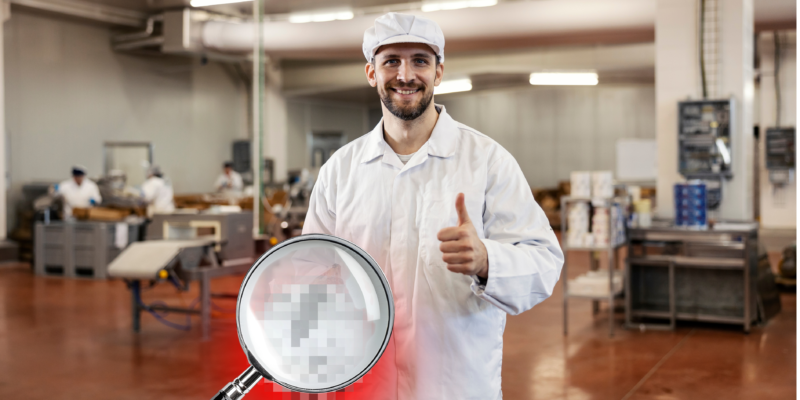 Mitarbeiter in einem deutschen Schlachthof mit Lupe – Symbol für Transparenz und Überwachung der Schlachtindustrie