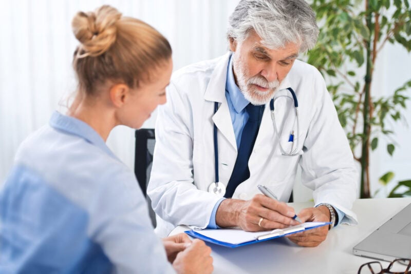 Arzt erklaert seiner Patientin den Befund