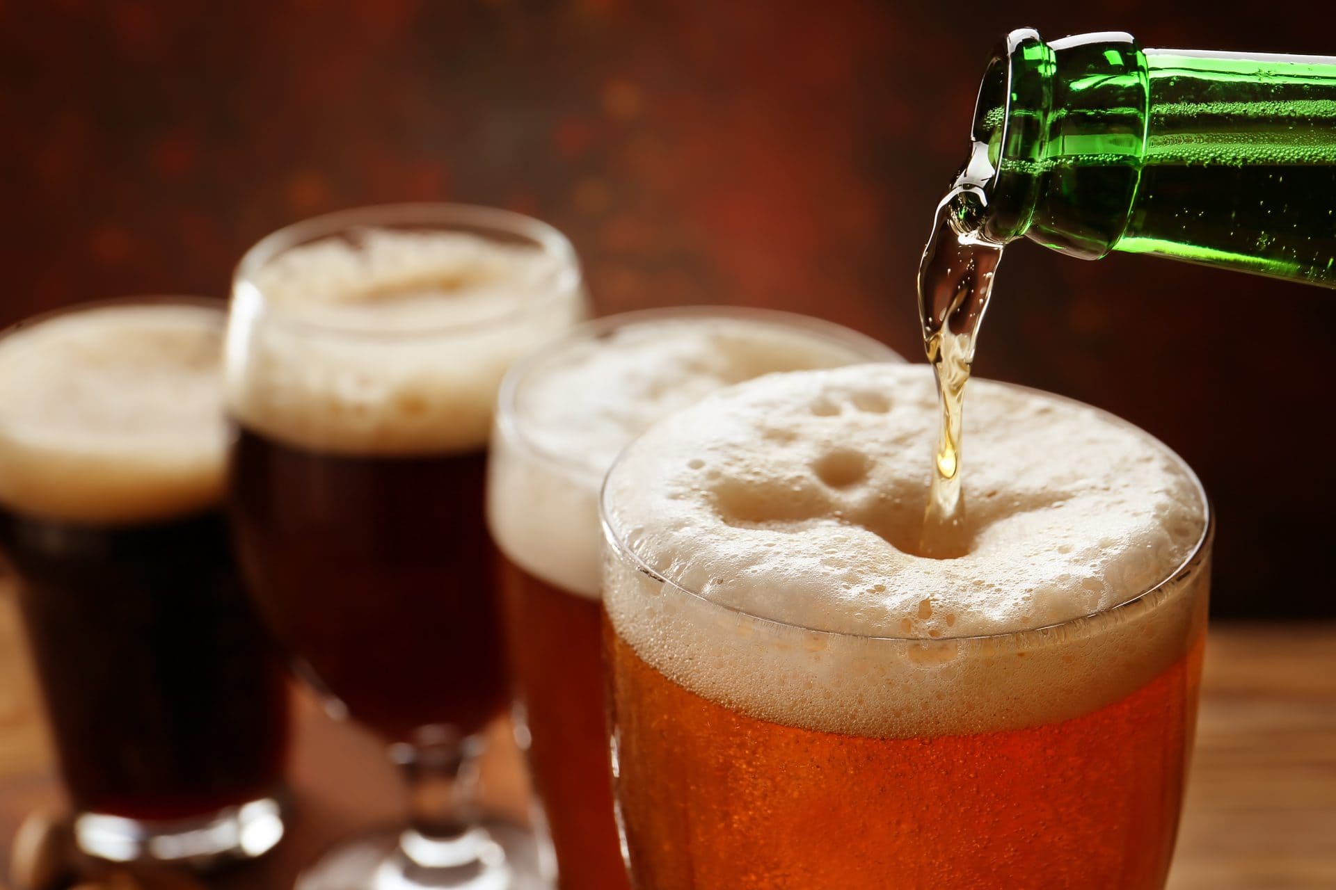 Frisches Bier wird in ein Pilsner-Glas eingegossen mit Schaumkrone