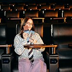 Billie Eilish x iChoc: Die vegane Schokolade zum Kinostart, die alle haben wollen Billie Eilish im Kinosessel mit zwei Tafeln der veganen iChoc Limited Edition zum Kinostart von Hit Me Hard and Soft