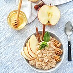 Vegan und Cholesterin 2026: was die größte Meta-Analyse zeigt – und welche Lebensmittel den LDL-Wert wirklich senken Schale mit Haferflocken, Walnüssen, veganem Honig, Leinsamen und Beeren auf Holztisch – Lebensmittel mit cholesterinsenkender Wirkung