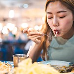 Vegan auf Reisen 2026: der ehrliche Praxis-Guide für Backpacker, Städtetrips und 14-Stunden-Flüge Person mit Rucksack vor exotischer Streetfood-Szene, vegan reisen in Asien mit Buddha Bowl in der Hand
