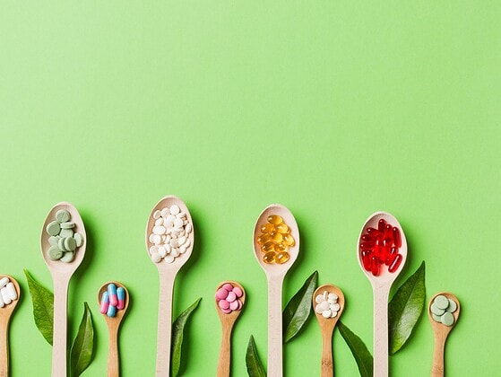 Vegane Vitamine in Form von Lebensmitteln und Supplementen: Beeren, Avocado, Algenöl-Kapseln, Vitamin-D-Tropfen