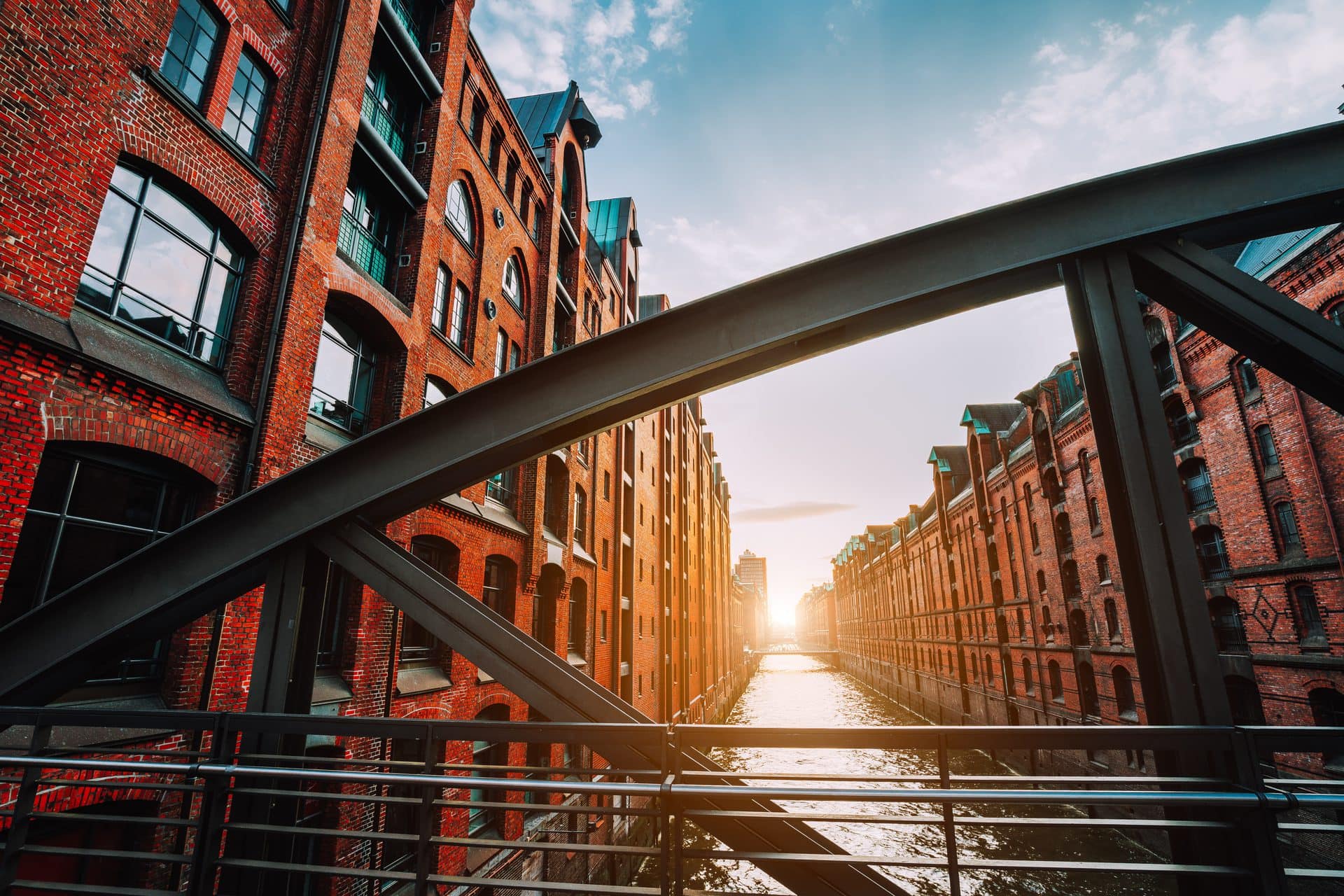 Hamburger Speicherstadt mit roten Backsteinhäusern an einem Kanal bei Sonnenuntergang