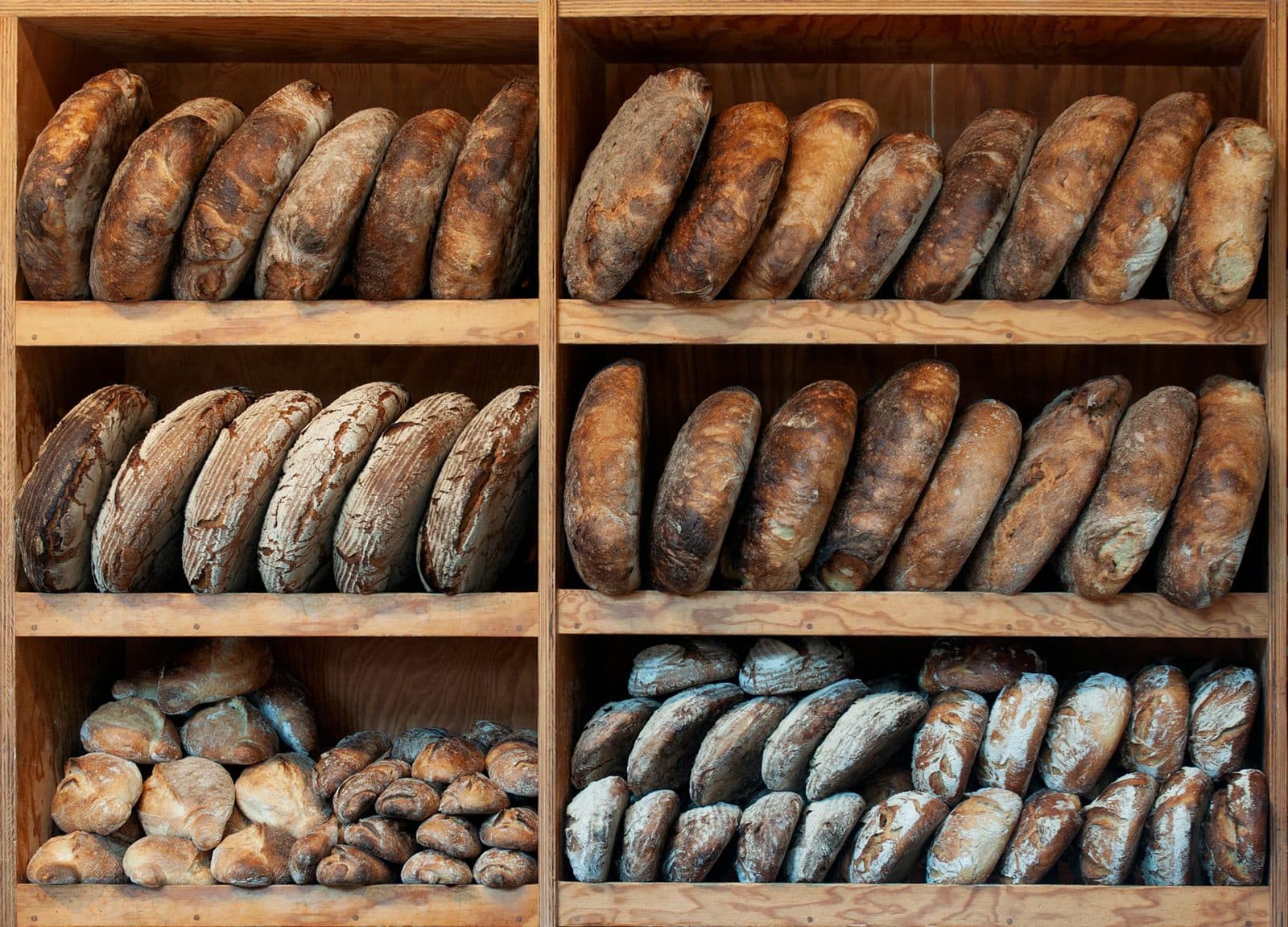 Frisch gebackenes Sauerteigbrot mit goldener Kruste auf rustikalem Holzbrett