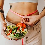 Vegan abnehmen 2026: was die Studien wirklich zeigen und welche Fallen das Internet noch immer aufstellt Frische Gemüseplatte mit Hülsenfrüchten, Quinoa und einer Personenwaage, helle Küche im Hintergrund