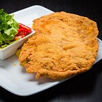 Veganes Schnitzel Test 2026: Die 9 besten Marken im ehrlichen Vergleich Goldbraun gebackenes veganes Schnitzel auf weißem Teller mit Zitronenscheibe, Petersilie und Kartoffelsalat im Hintergrund