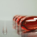Vitamin B12 vegan 2026: was die Studienlage wirklich sagt und welche Supplemente funktionieren Vitamin-B12-Supplement-Flasche mit roten Cyanocobalamin-Tabletten auf Holzbrett, daneben Bluttest-Röhrchen