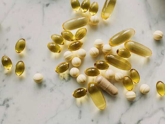 Sonnenstrahlen fallen durch ein Fenster auf Vitamin-D-Supplement-Tabletten und einen Bluttest-Auswertungs-Bericht