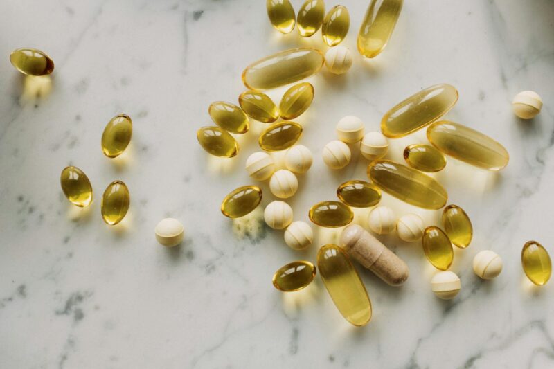 Sonnenstrahlen fallen durch ein Fenster auf Vitamin-D-Supplement-Tabletten und einen Bluttest-Auswertungs-Bericht