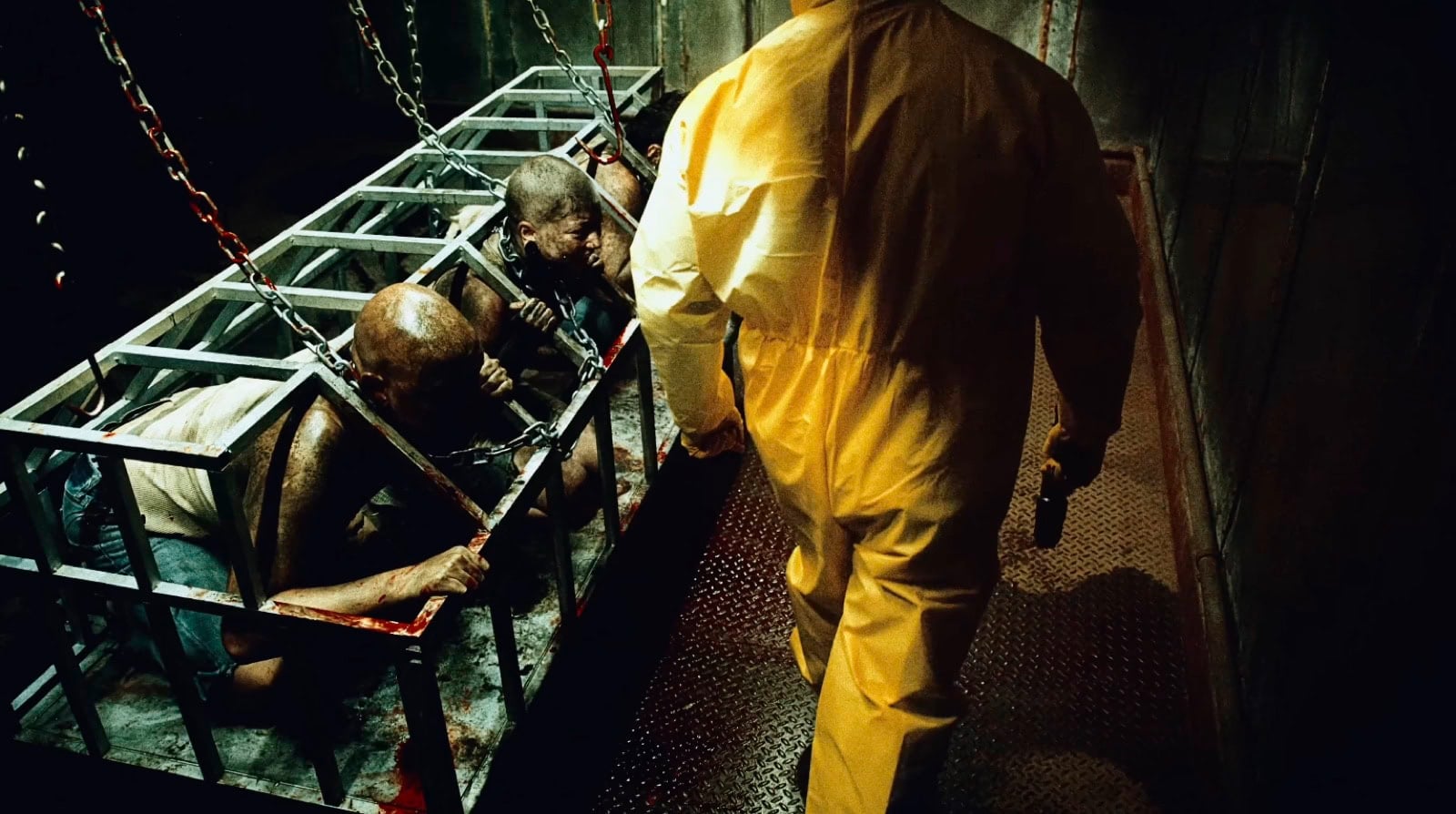 People in cages and a figure in a protective suit, slaughterhouse scene from the Dehumanized video