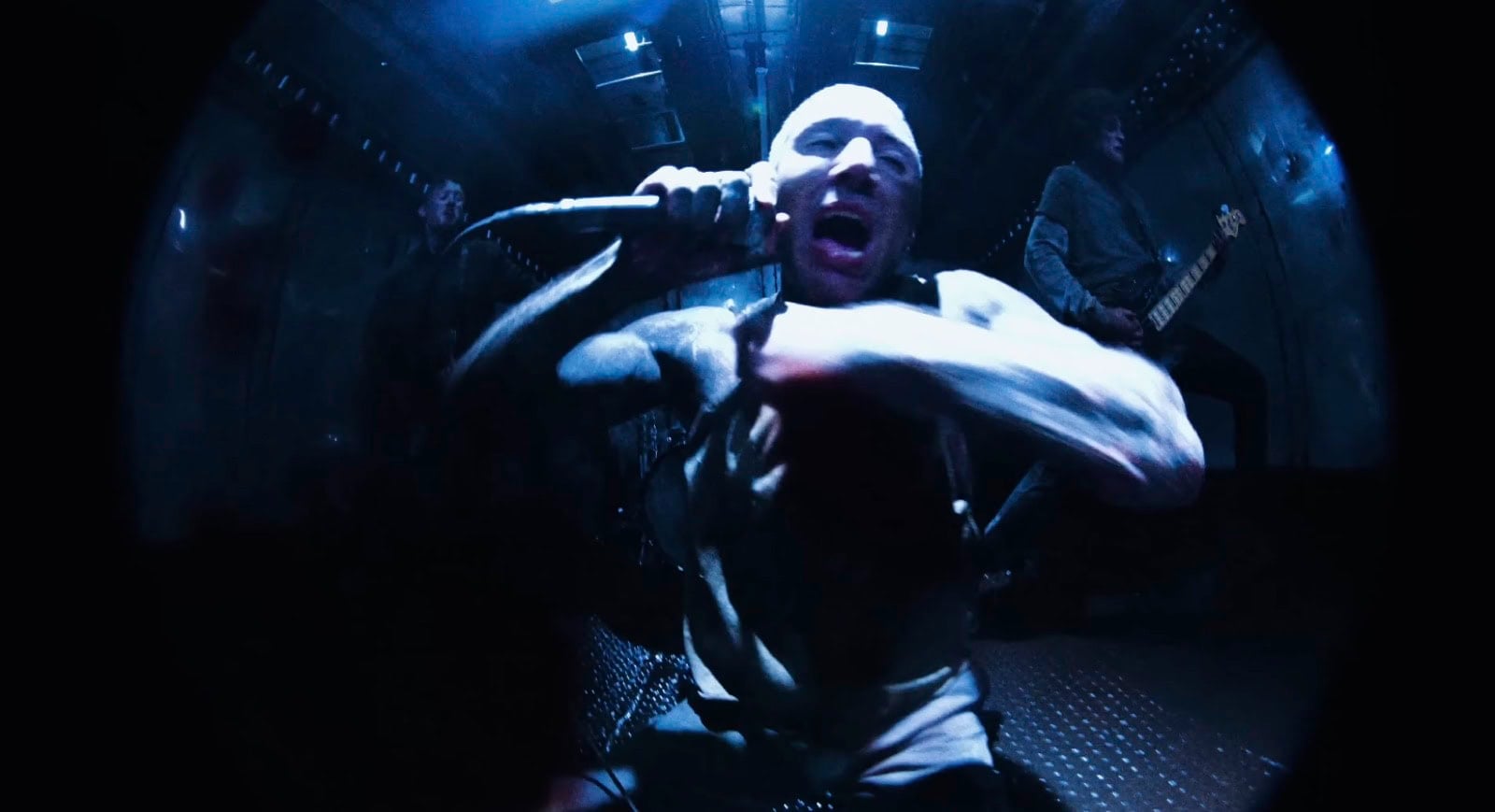 Oli Sykes of Bring Me The Horizon screams into the microphone in the Dehumanized music video