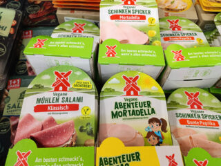Vegane Fleischalternativen wie Salami und Mortadella als pflanzlicher Aufschnitt im Regal