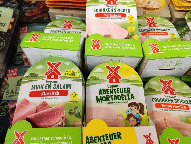 Vegane Fleischalternativen wie Salami und Mortadella als pflanzlicher Aufschnitt im Regal