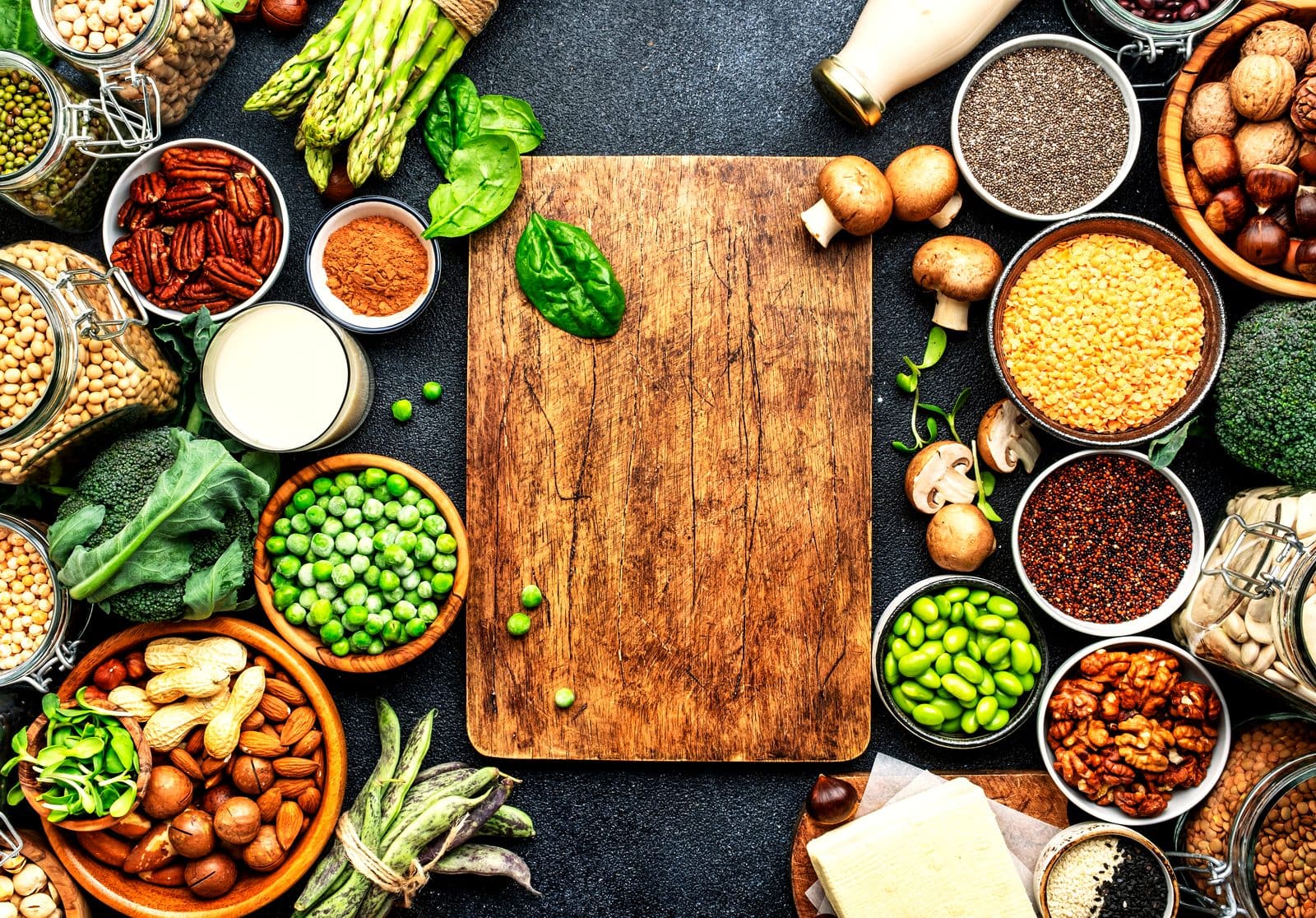 Flatlay mit veganen Lebensmitteln, Hülsenfrüchten, Tofu, Nüssen und Pflanzendrink von oben