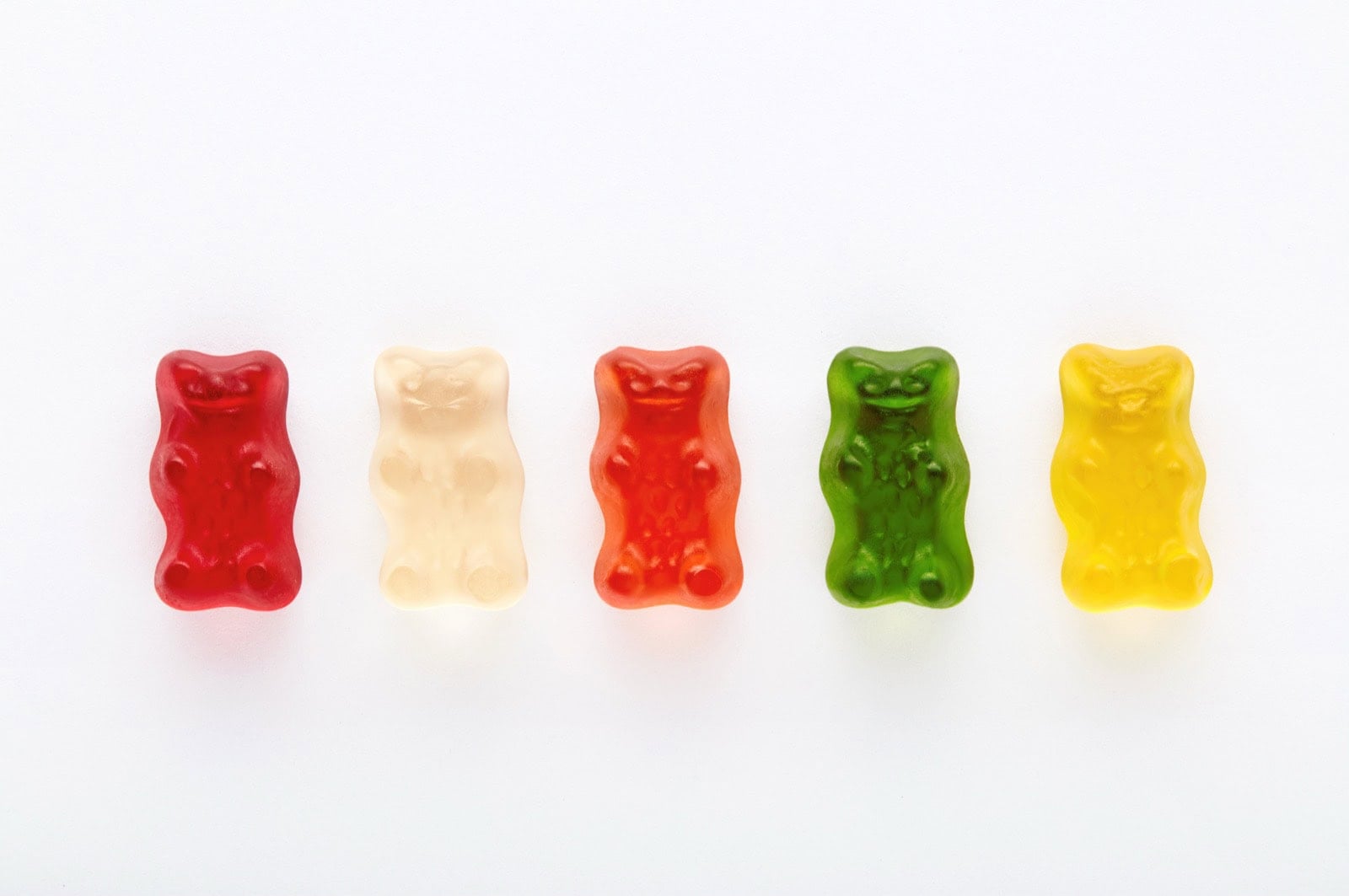 Bunte Gummibärchen-Auswahl auf weißem Hintergrund, vegane Süßigkeiten