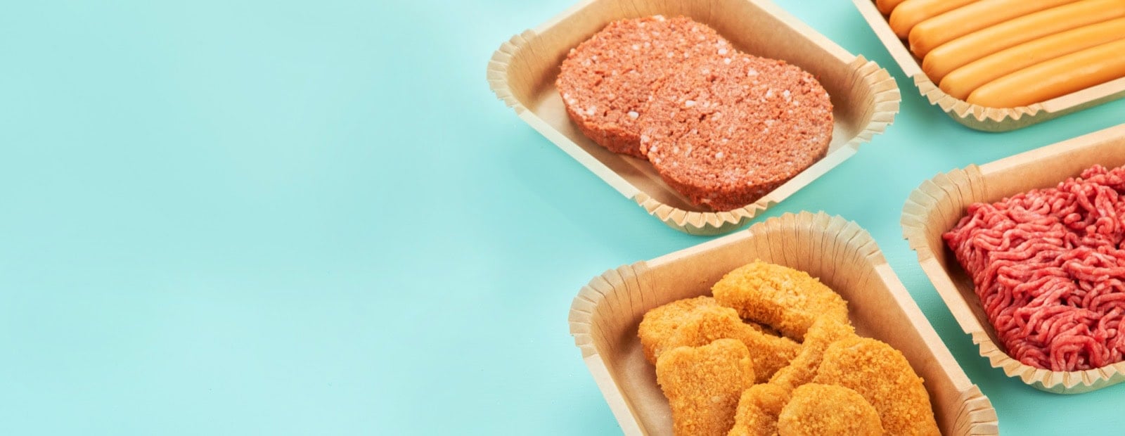 Pflanzliche Burger, Wurst, Nuggets und Hack in Schalen nebeneinander