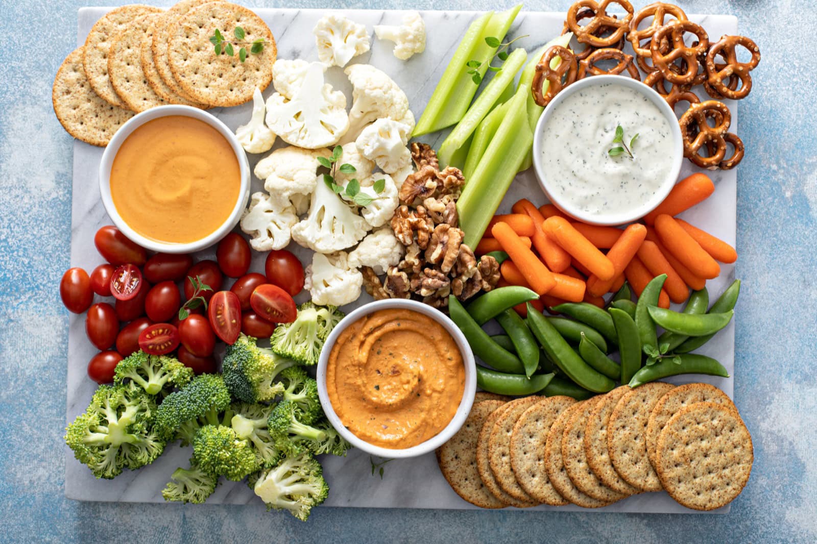 Pflanzliches Snack-Board mit Gemüse, Crackern und veganen Aufschnitt-Scheiben