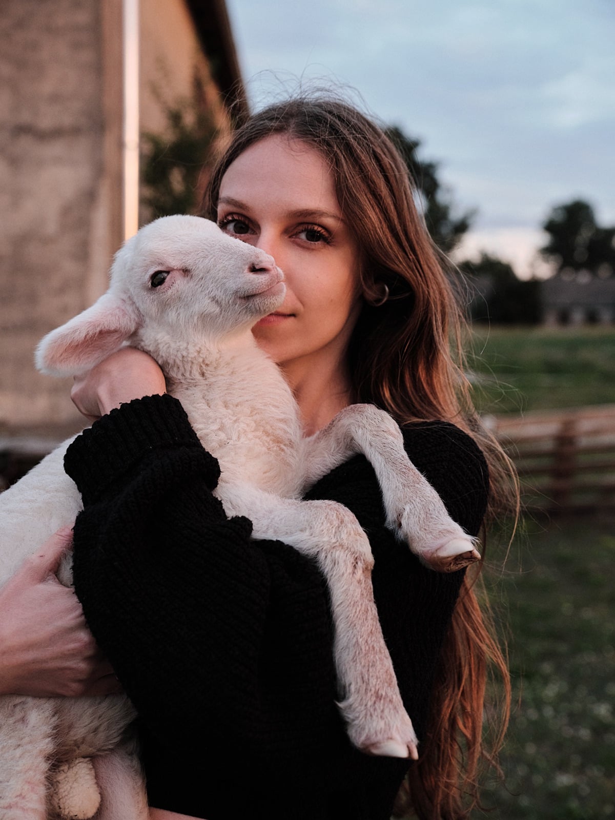 Aglaja Brix hält ein gerettetes Lamm auf einem Lebenshof im Arm
