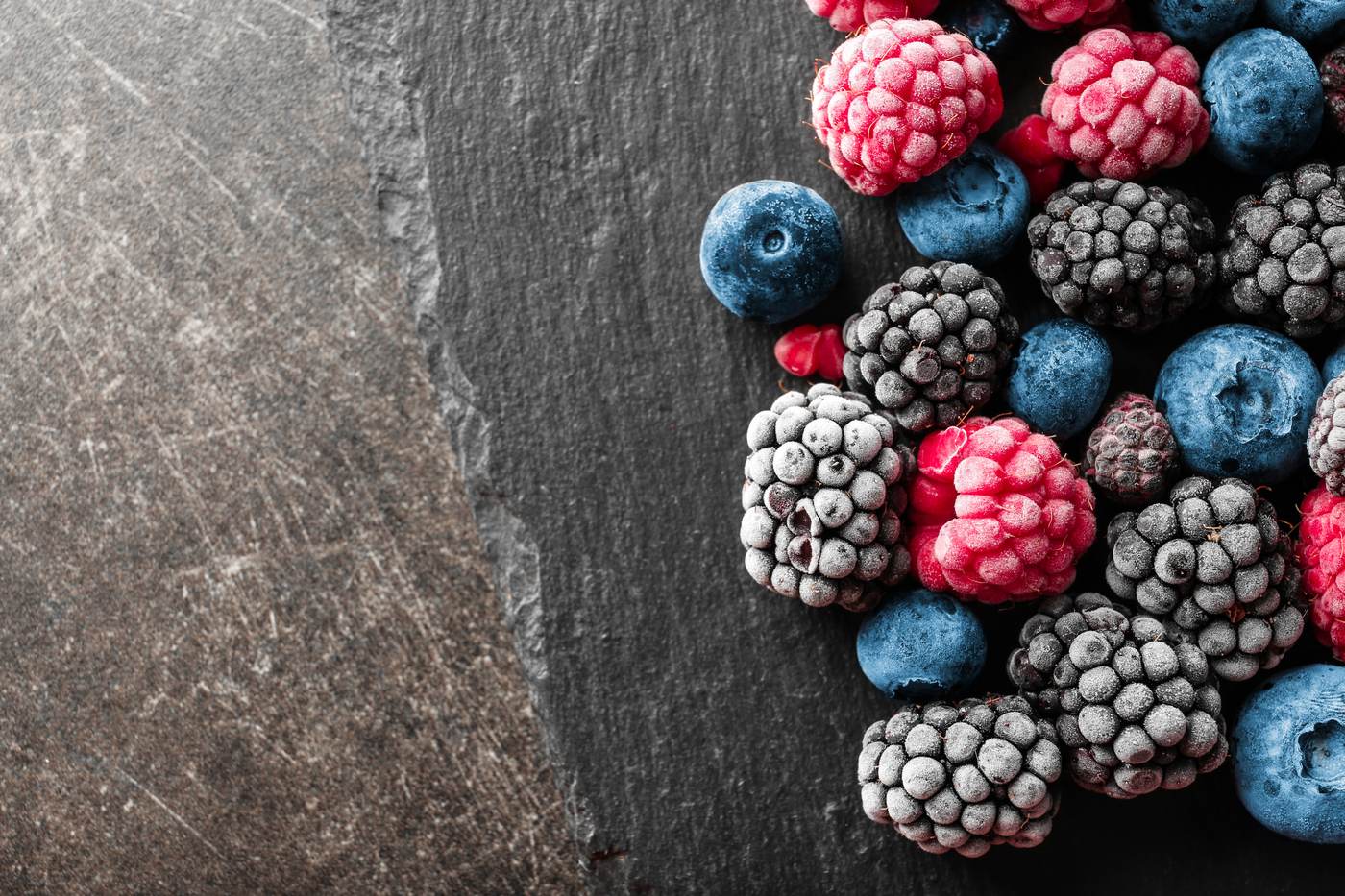 Tiefgefrorene Beeren auf einer Schieferplatte