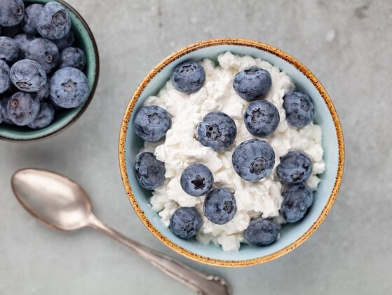 Schale mit körnigem Cottage Cheese und frischen Blaubeeren