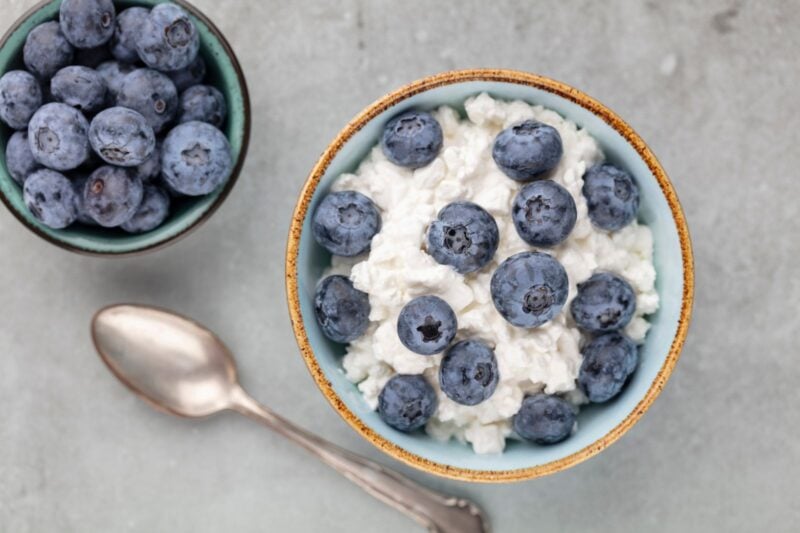 Schale mit körnigem Cottage Cheese und frischen Blaubeeren