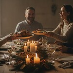 Familie sitzt gemeinsam an einem festlich gedeckten Tisch und teilt Essen