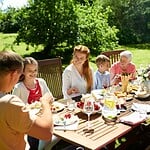 Familie beim festlichen gemeinsamen Essen am gedeckten Tisch