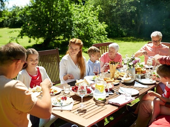 Familie beim festlichen gemeinsamen Essen am gedeckten Tisch