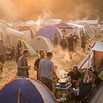 Vegan auf Festival: So kommst du satt durchs Wochenende Festival-Campingplatz mit bunten Zelten in der goldenen Abendstunde
