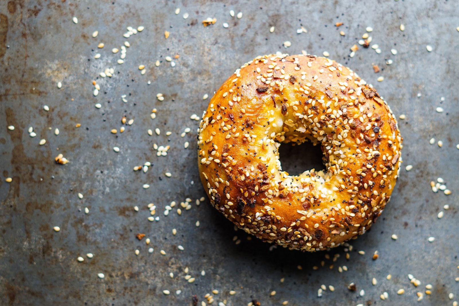 Fresh bagels with seasoning on a board